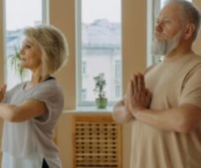 Image of elderly individuals practicing Pranamasana, also known as the prayer pose in yoga.
