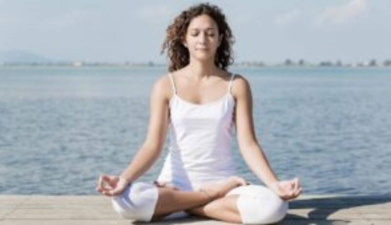 A lady practicing Pranayama in Padmasana, the cross-legged lotus pose.